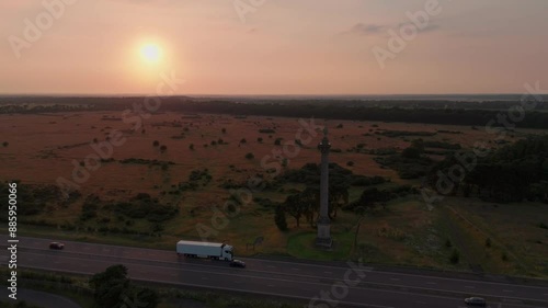 Sundown Sky Illuminated Elveden War Memorial Column In West Suffolk, England. Aerial Shot  photo