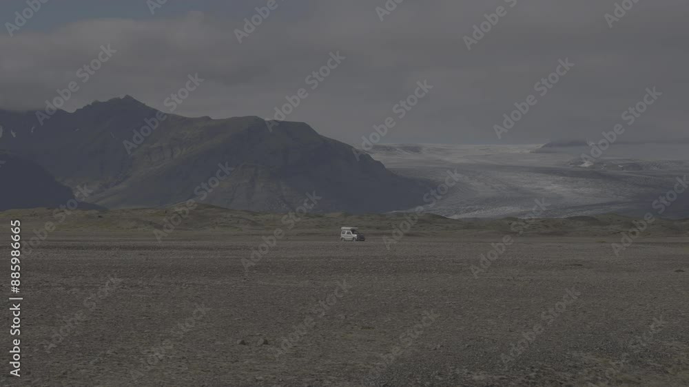 A lonely white car driving on a road with mountains and an ice glacier in the background (S-Log 3, ProRes 422HQ) A lonely white car driving on a road with mountains and an ice glacier in the background (S-Log 3, ProRes 422HQ)