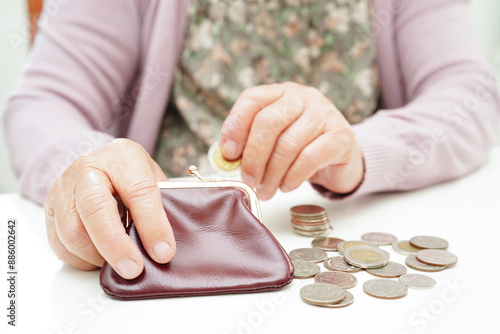 Retired elderly woman counting coins money and worry about monthly expenses and treatment fee payment. photo