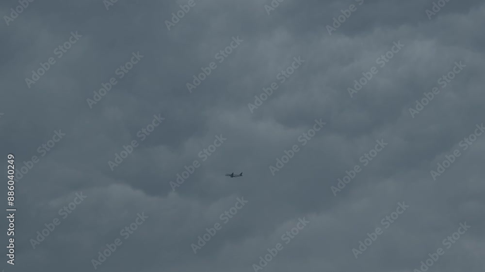 Airplane flying across dramatic overcast sky Airplane flying across dramatic overcast sky
