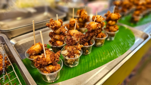 Fried crispy fermented pork, sour pork, Fried pork skewers. Thai street food, Fried food with batter for sale at Thai street market. Deep fried food skewer photo