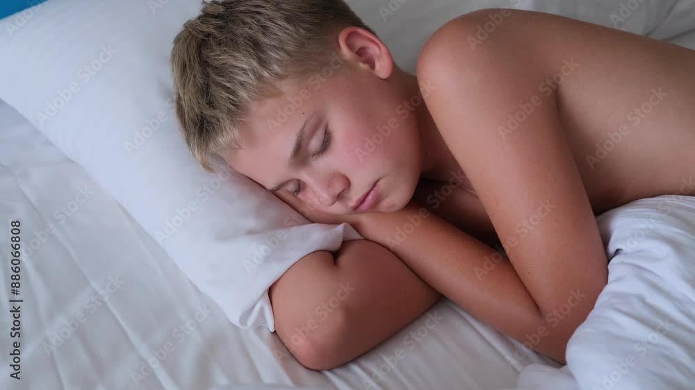 Teen boy sleeping in bed, representing restful sleep and childhood innocence Teen boy sleeping in bed, representing restful sleep and childhood innocence