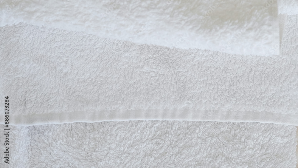 White and beige towels neatly stacked, adding a touch of elegance and comfort. White and beige towels neatly stacked, adding a touch of elegance and comfort.