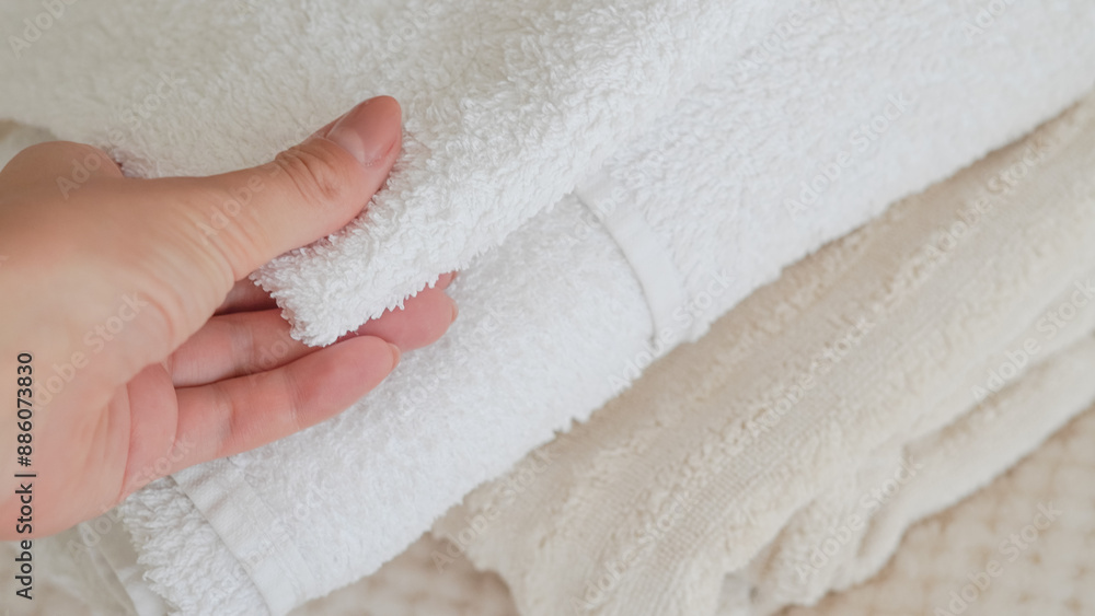 White and beige towels neatly stacked, adding a touch of elegance and comfort. White and beige towels neatly stacked, adding a touch of elegance and comfort.
