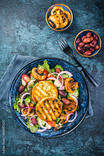 Fresh salad with grilled cheese, tomatoes, lettuce, grilled champignons, cucumber and olives