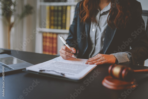 Lawyer women holding pen with contract or agreement document to the customer for signing in courtroom legal, Sign a contract business.