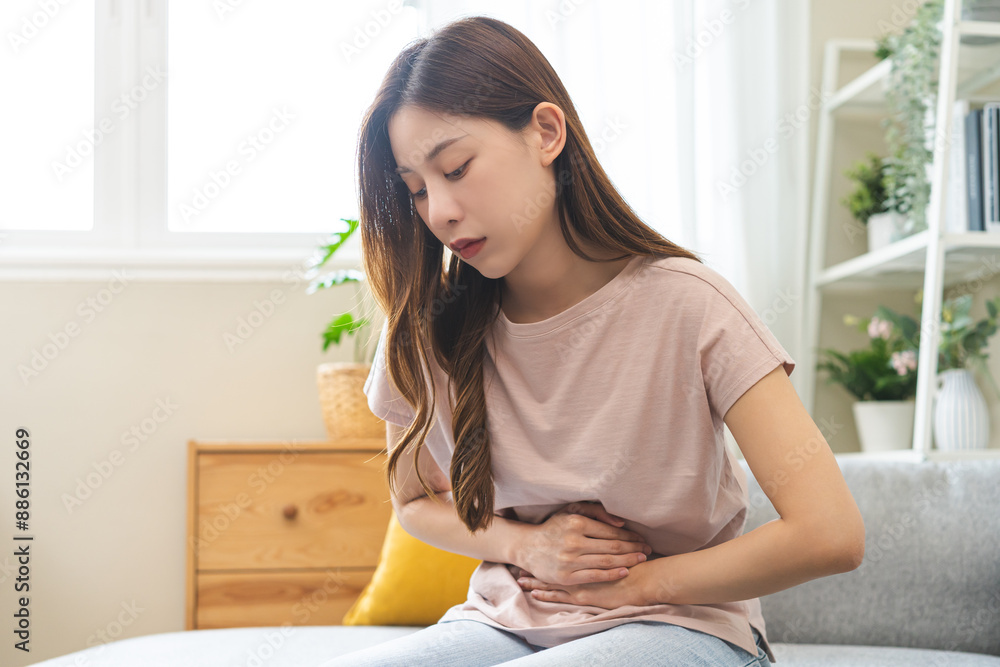 Flatulence asian young woman intolerance hand in stomach ache, suffer from food poisoning, abdominal pain and colon problem, gastritis or diarrhoea when at home. Patient belly, abdomen or inflammation Flatulence asian young woman intolerance hand in stomach ache, suffer from food poisoning, abdominal pain and colon problem, gastritis or diarrhoea when at home. Patient belly, abdomen or inflammation