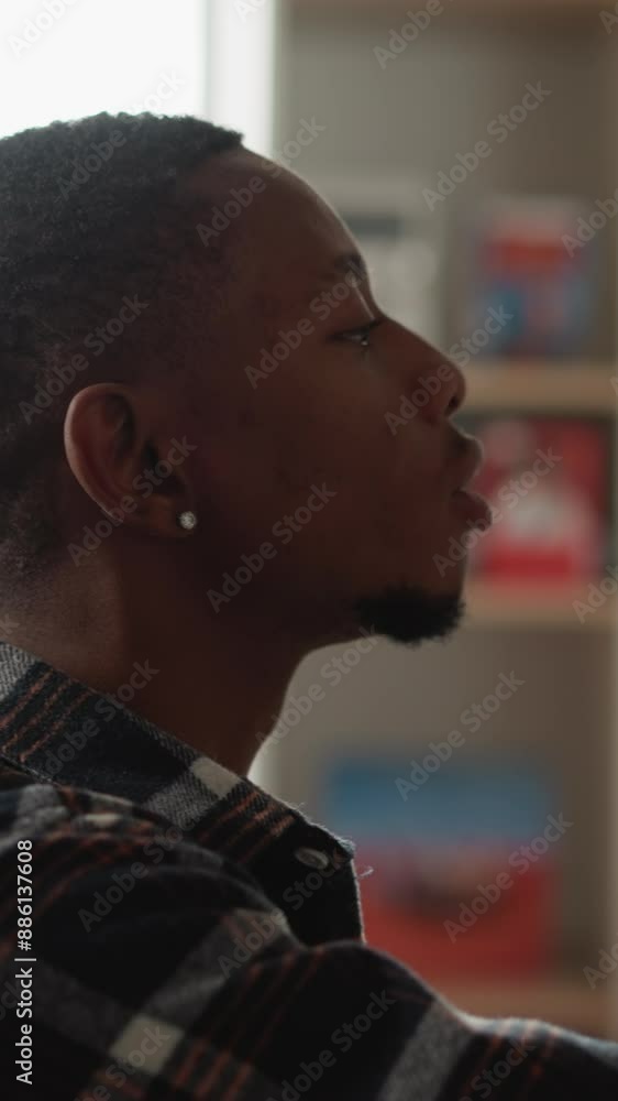 Student takes book from shelf in library. African American man finds textbook for thesis writing in college information center. Guy chooses novel Student takes book from shelf in library. African American man finds textbook for thesis writing in college information center. Guy chooses novel