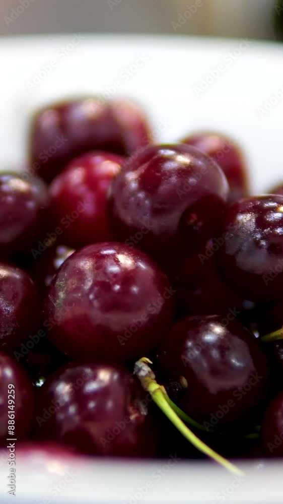 Fresh cherries rotate on a white plate. Juicy fruits against a dark backdrop, macro views. Promoting healthy nutrition and a vegetarian diet. Well-lit, appetizing presentation. Fresh cherries rotate on a white plate. Juicy fruits against a dark backdrop, macro views. Promoting healthy nutrition and a vegetarian diet. Well-lit, appetizing presentation.