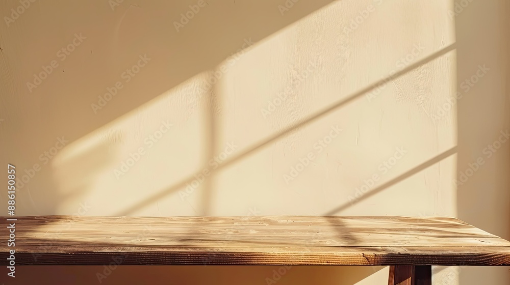 Minimalist wooden table top with beige wall and sunlight casting shadows Minimalist wooden table top with beige wall and sunlight casting shadows