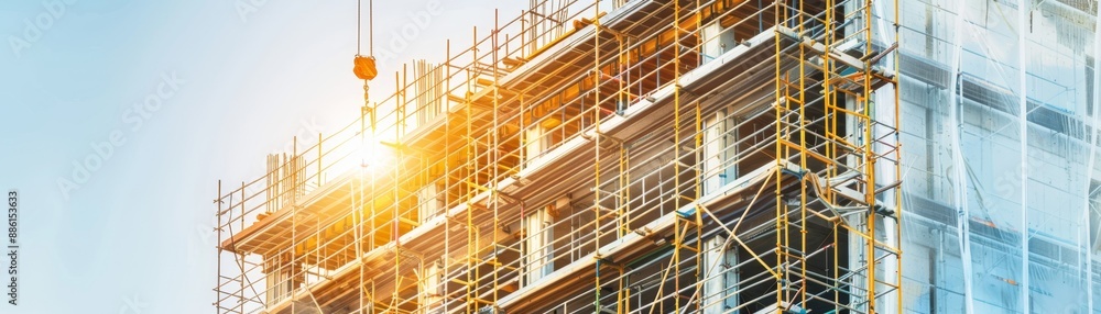 Towering Symbol of Urban Growth, Multi-story Building Under Construction with Scaffolding and Materials Towering Symbol of Urban Growth, Multi-story Building Under Construction with Scaffolding and Materials