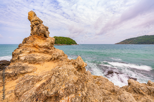 On top of this small island is a strangely shaped rock. Tourists like to climb up and take photos. In front of the island is the Isle of Man. And Nai Harn Beach has wind turbines on the side. photo