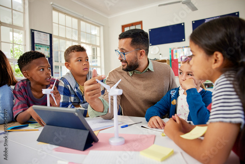 Male teacher explaining wind turbines to students