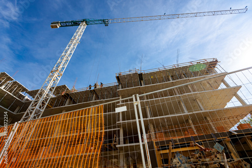 Construction site fenced with plastic orange safety mesh, hollow quadratic shape, fence