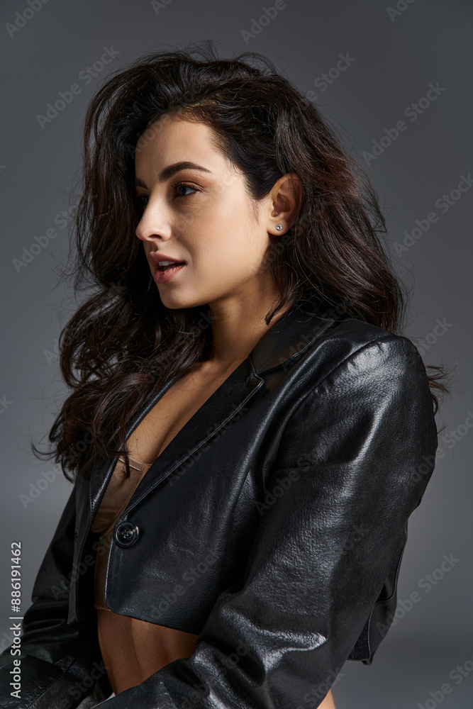 Stylish young woman strikes a confident pose in a black leather jacket. Stylish young woman strikes a confident pose in a black leather jacket.
