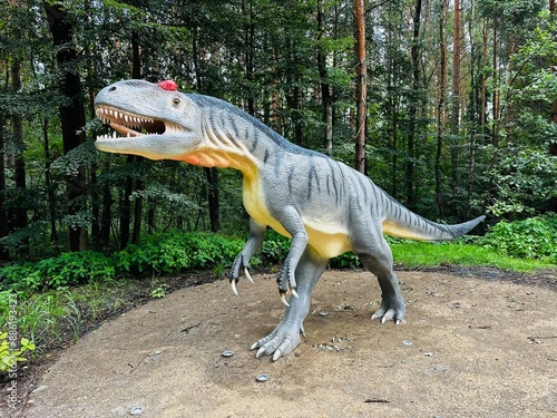 Allosaurus dinosaur. Realistic figure of an Allosaurus dinosaur inforest park in Kazimierz Sosnowiec. Prehistoric predator create a fascinating element of the landscape, attracting dinosaur lovers. photo