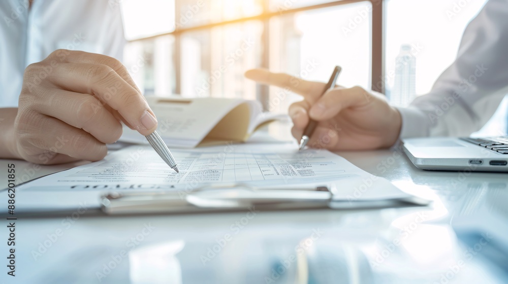 Hands of a financial advisor showing a tax document to a client, with the advisor's finger pointing at important information and space for text. Hands of a financial advisor showing a tax document to a client, with the advisor's finger pointing at important information and space for text.