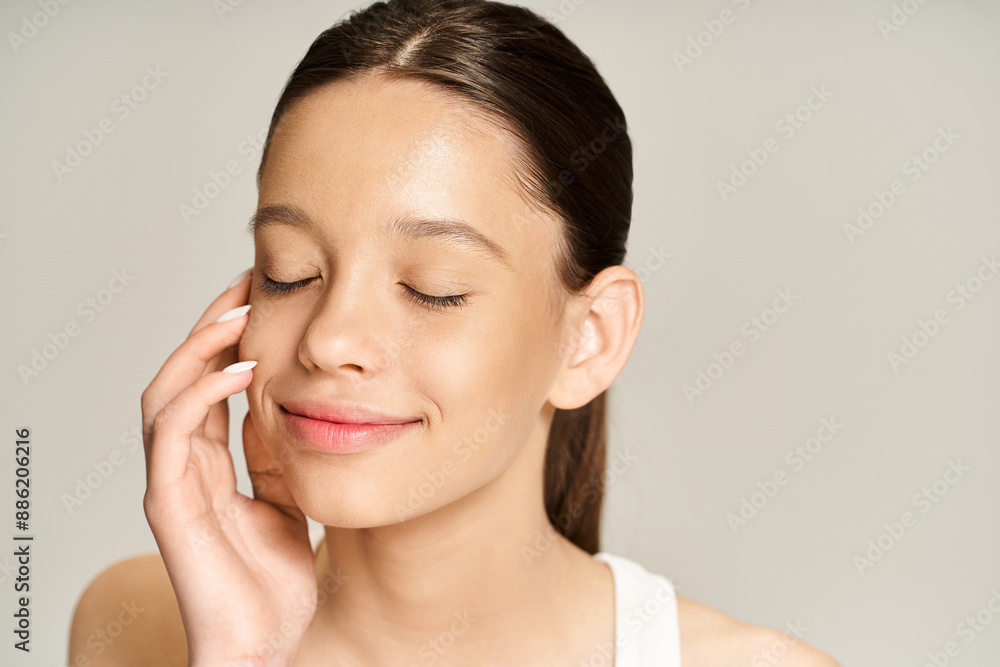 A stylish teenage girl with her eyes closed, holding her hand to her ear in a serene moment of connection. A stylish teenage girl with her eyes closed, holding her hand to her ear in a serene moment of connection.