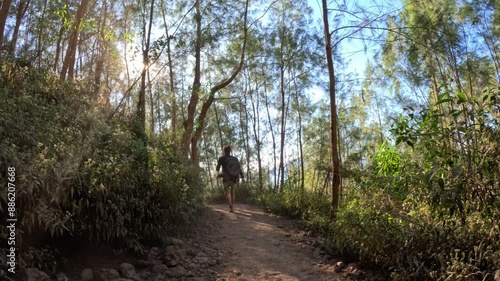 Person is hiking up the green path to Mount Batur on an amazing sunny day with a blue sky, static and colorful photo