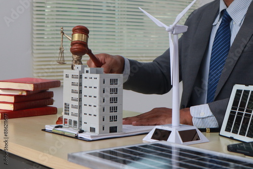 A businessman in a suit sits at a table discussing the Clean Energy Act, which incentivizes renewable energy adoption, clean raw material use in energy production, and energy-efficient transportation. photo