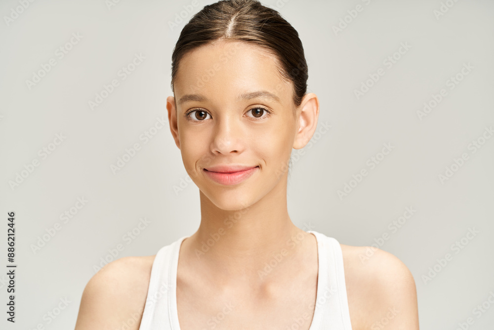 A good-looking teenage girl poses actively in a stylish white tank top, radiating grace and elegance. A good-looking teenage girl poses actively in a stylish white tank top, radiating grace and elegance.