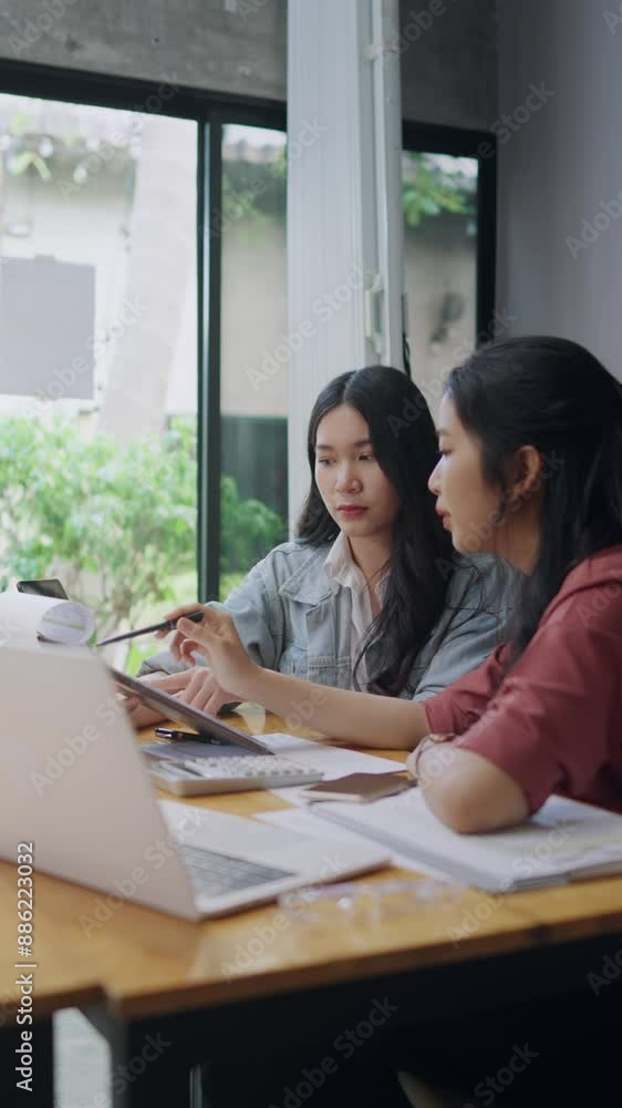 Two Asian university students tutoring together before examination Two Asian university students tutoring together before examination