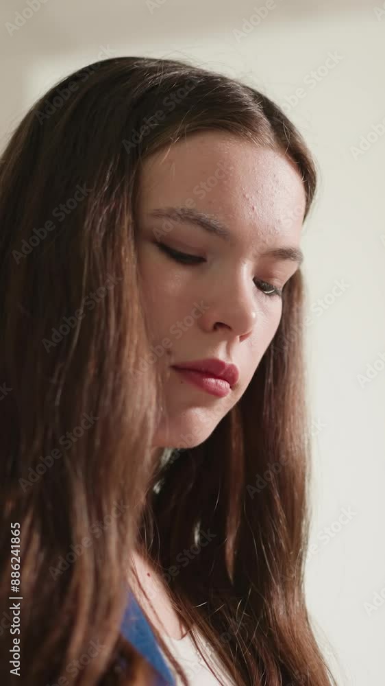 Concentrated woman leans on bookcase closeup. Brunette lady looks down standing in bookshop closeup. Student visits literature storage for materials Concentrated woman leans on bookcase closeup. Brunette lady looks down standing in bookshop closeup. Student visits literature storage for materials