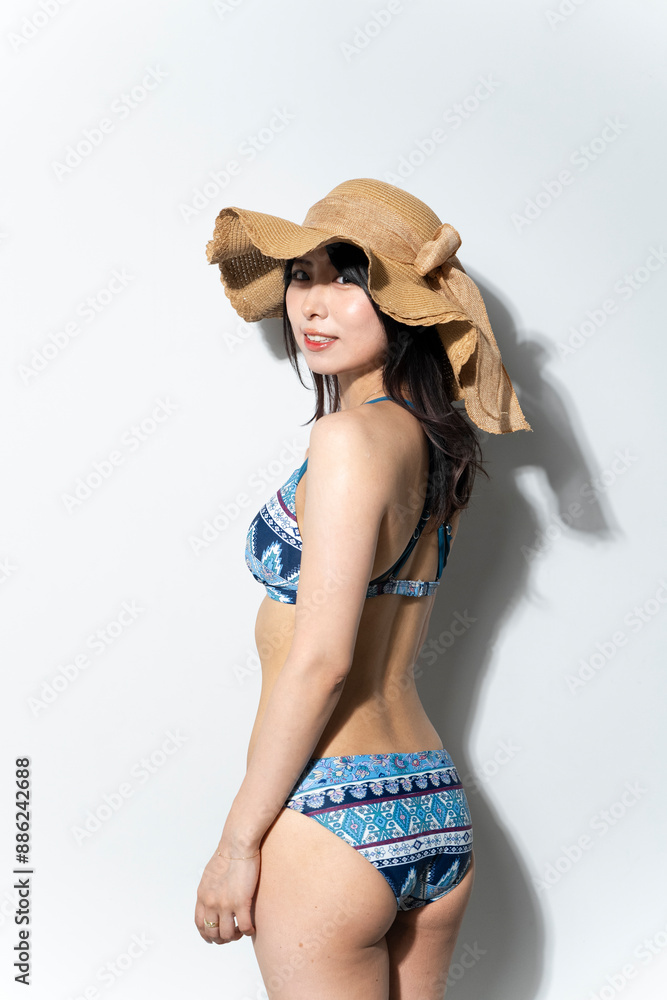 麦わら帽子を被った水着の女性
