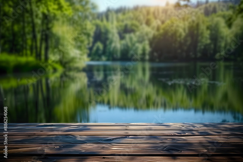 The empty wooden table top with blur background of summer lakes green forest. 