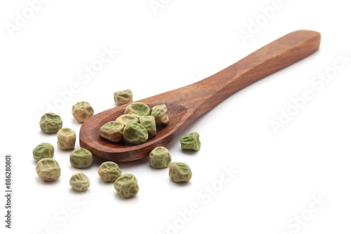 Front view of a wooden spoon filled with dry Organic Green Peas  (Pisum sativum) seeds. Isolated on a white background. photo