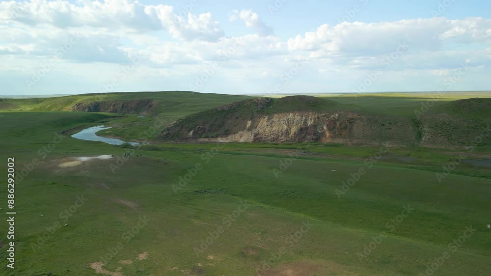 Ruins Alongside a River Flowing Through Expansive Green Fields in the Rural Region of Kazakhstan, Central Asia - Aerial Pullback Shot Ruins Alongside a River Flowing Through Expansive Green Fields in the Rural Region of Kazakhstan, Central Asia - Aerial Pullback Shot