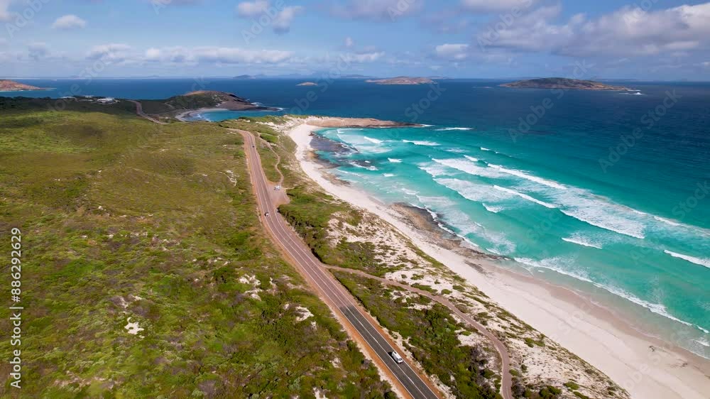 4K drone video of a camper van driving along a stunning long road next to a beautiful beach in Esperance, Western Australia. White waves from the blue ocean are crashing against the white sand beach. 4K drone video of a camper van driving along a stunning long road next to a beautiful beach in Esperance, Western Australia. White waves from the blue ocean are crashing against the white sand beach.