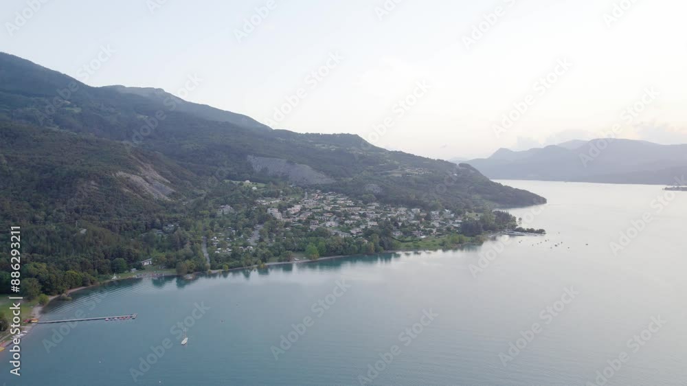 Serre Poncon Lake In Morning Sunlight With Foggy Background. Reservoir In Hautes-Alpes, France. aerial pullback shot Serre Poncon Lake In Morning Sunlight With Foggy Background. Reservoir In Hautes-Alpes, France. aerial pullback shot