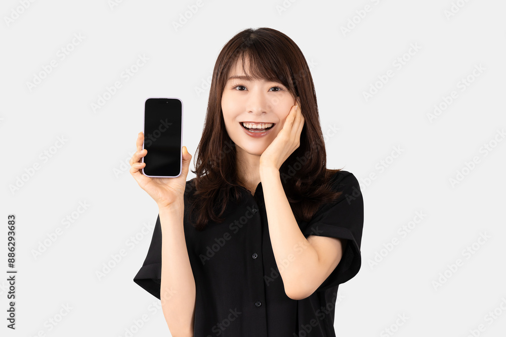 スマホを持って驚き喜ぶ笑顔の日本人女性