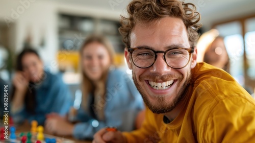 A close-up of a smiling man during an indoor board game session with friends, showcasing the joy of social interaction, fun, and the lighthearted moments shared with loved ones.