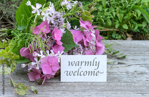 Greeting card with pink hydrangeas, soapwort, oregano and text: warmly welcome