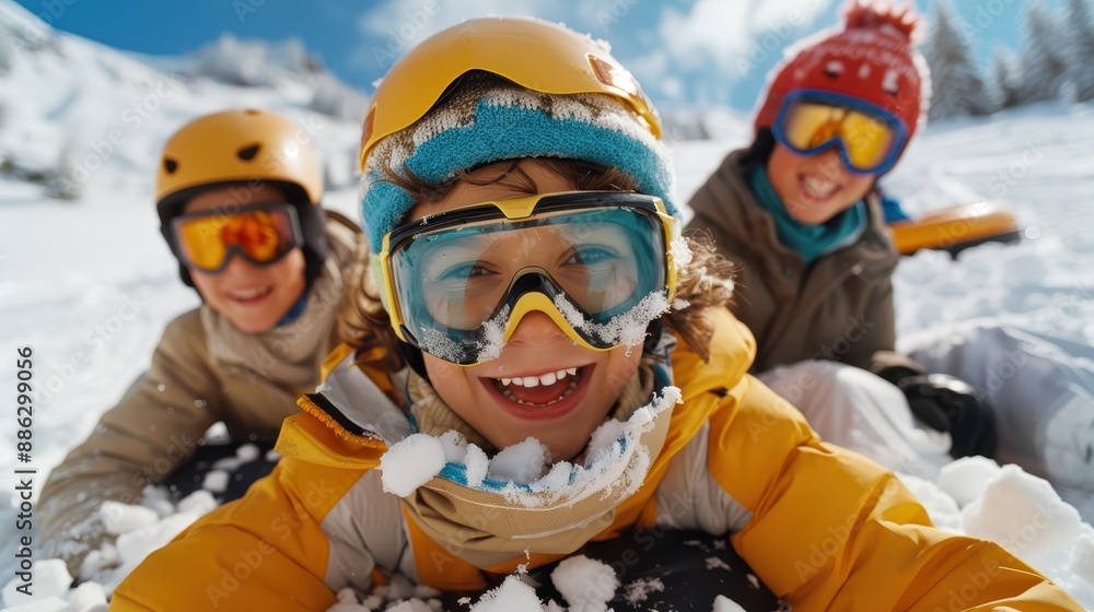 Three individuals dressed in winter gear and helmets laying down in the snow, enjoying a playful moment in a snowy landscape surrounded by mountains and clear blue skies. Three individuals dressed in winter gear and helmets laying down in the snow, enjoying a playful moment in a snowy landscape surrounded by mountains and clear blue skies.