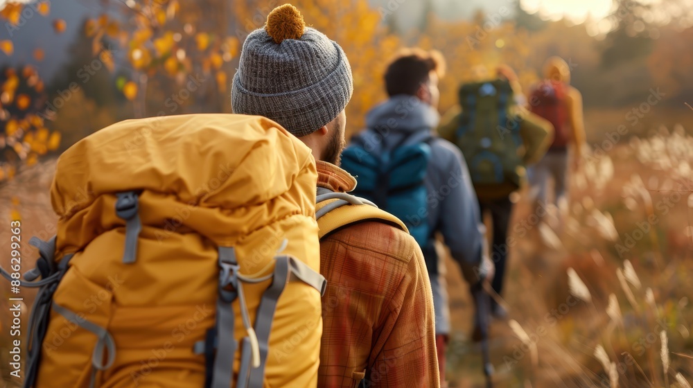 Hikers with backpacks traverse a trail in a fall landscape, surrounded by golden grasses and autumn foliage, capturing the essence of outdoor adventure and seasonal beauty. Hikers with backpacks traverse a trail in a fall landscape, surrounded by golden grasses and autumn foliage, capturing the essence of outdoor adventure and seasonal beauty.