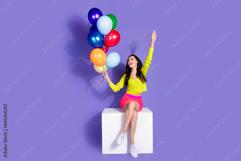 Photo of lovely cheerful girl wear trendy clothes hold helium balloon look empty space isolated on purple color background Photo of lovely cheerful girl wear trendy clothes hold helium balloon look empty space isolated on purple color background