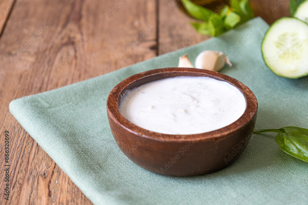White dip sauce - sour cream or yogurt in wooden bowl. Greek sauce White dip sauce - sour cream or yogurt in wooden bowl. Greek sauce