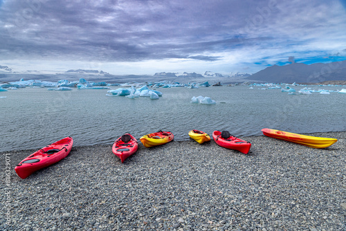 Colorful kayaks resting on a rocky beach awaiting kayakers in iceland photo