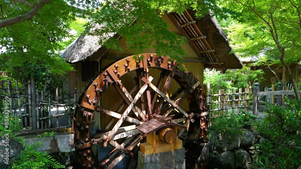 Beautiful scenery with spinning water wheel at traditional Japanese shrine