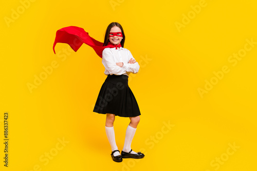 Full size photo of cute schoolgirl superhero crossed arms empty space wear uniform isolated on yellow color background