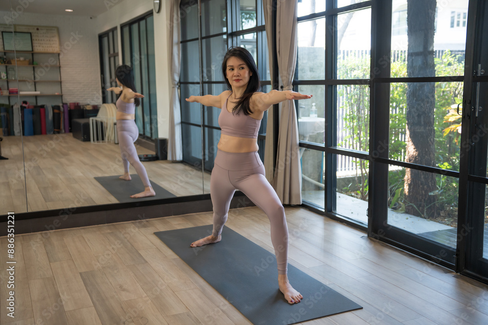 Fototapeta premium Female happiness Attractive young asian woman doing yoga stretching exercise on mat yoga & fitness exercises. Healthy lifestyle Calmness and relax