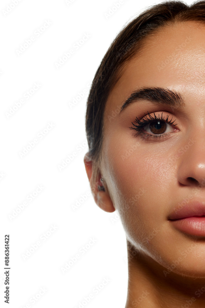 Close-up of of woman face, focusing on eye, eyebrow, and lips, smooth skin, natural makeup, long eyelashes, well-groomed brow isolated on white background. Concept of beauty, cosmetology and cosmetics Close-up of of woman face, focusing on eye, eyebrow, and lips, smooth skin, natural makeup, long eyelashes, well-groomed brow isolated on white background. Concept of beauty, cosmetology and cosmetics