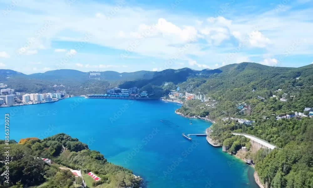 Breathtaking aerial view of coastal bay surrounded by lush green hills under clear blue sky Tranquil turquoise water contrasts beautifully with the vibrant greenery creating picturesque landscape Breathtaking aerial view of coastal bay surrounded by lush green hills under clear blue sky Tranquil turquoise water contrasts beautifully with the vibrant greenery creating picturesque landscape