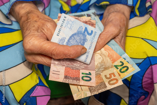 Obraz na płótnie Pensioner's finances. An old woman counts Brazilian money, Pension and budget of elderly people in Brazil. w salonie