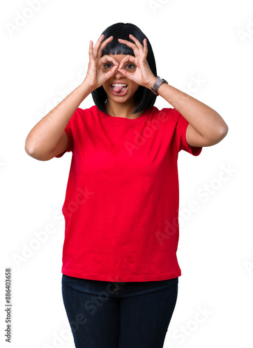 Beautiful young african american woman wearing glasses over isolated background doing ok gesture like binoculars sticking tongue out, eyes looking through fingers. Crazy expression.