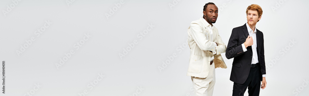 Two multicultural men in elegant attire stand together. Two multicultural men in elegant attire stand together.