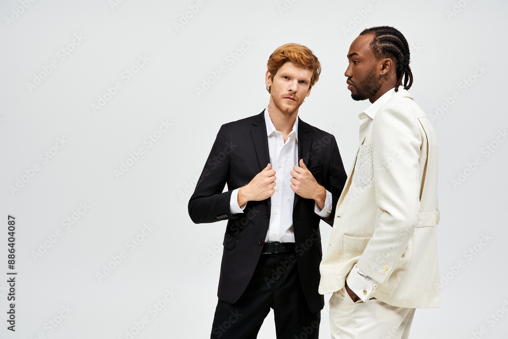 Two handsome multicultural men in stylish suits stand side by side. Two handsome multicultural men in stylish suits stand side by side.
